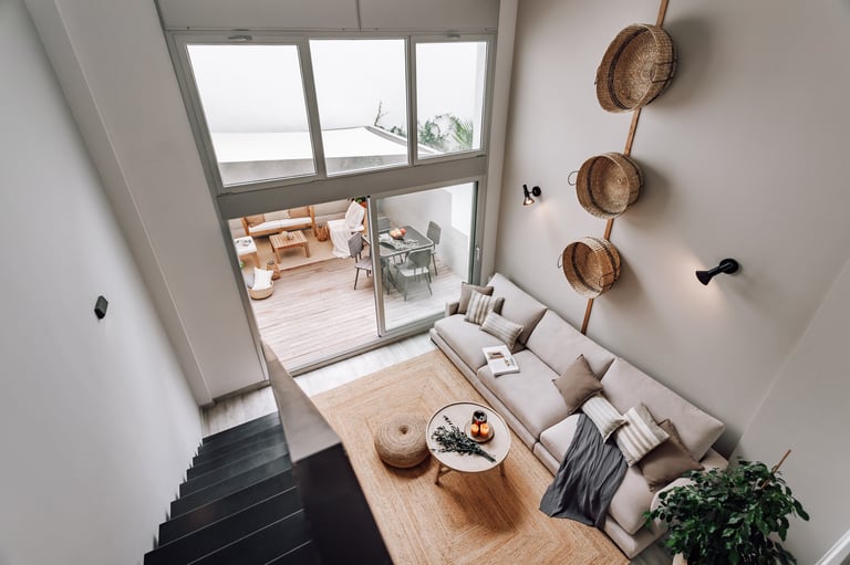 Modern living room with an iron staircase, natural wood finishes in Barcelona interior design