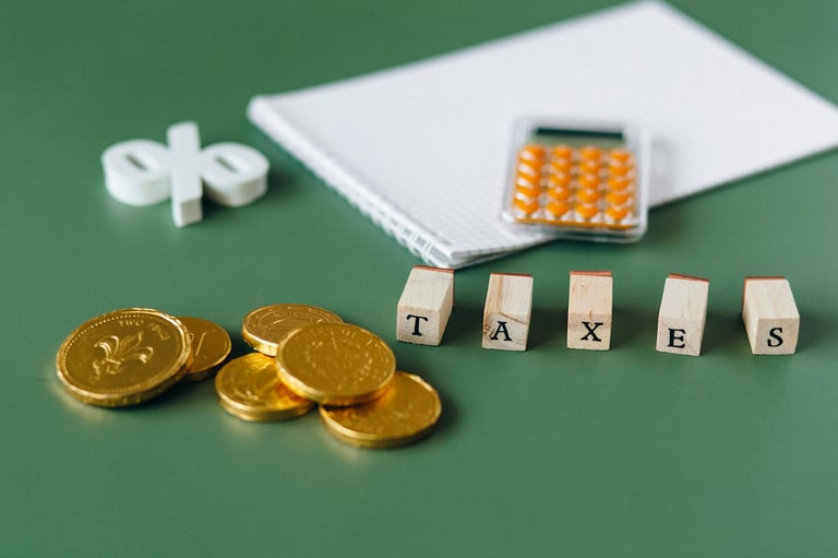 gold coins, calculator and word taxes show gold ira taxes and learning potential tax benefits