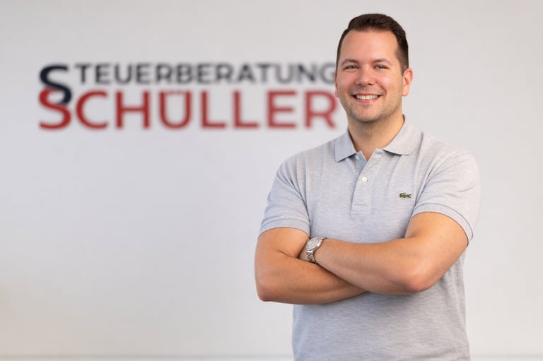 Steuerberater und Inhaber Niklas Schüller, im Hintergrund Schriftzug Steuerberatung Schüller