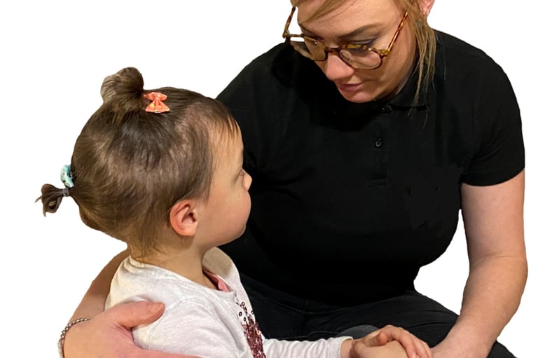 A first aider with her arm around a small child comforting them