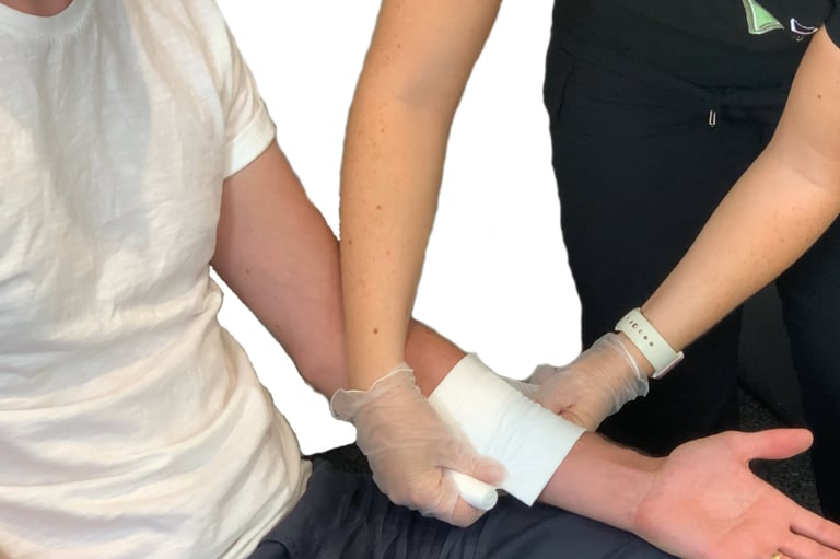 a first aid instructor demonstrating applying a banding on a persons forearm