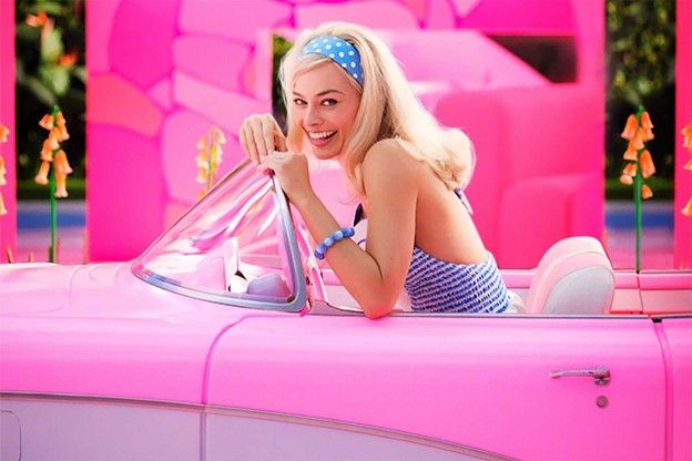 a woman in a bikinisuit sitting in a pink car