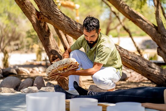 Un practicante realiza una sesión de terapia de sanación sonora utilizando un tambor chamánico al ai