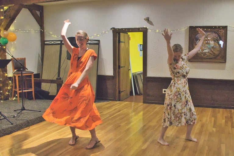 a woman in a orange dress dancing next to a woman in a floral dress