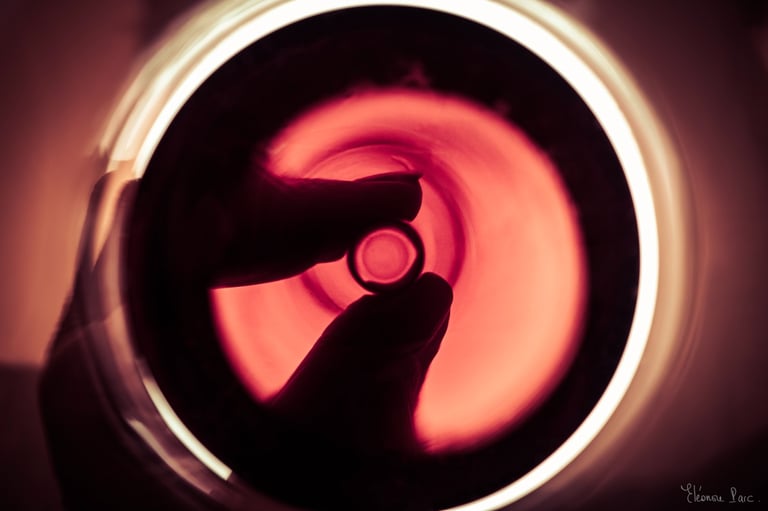 fond d’un verre de vin rougeavec main, lumière incandescente.