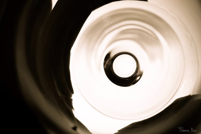 Cercle central d’un verre vu en plongée, ombres douces créant des formes fluides.