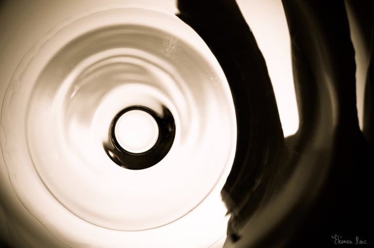 Cercle central d’un verre vu en plongée, ombre de la main sur la droite..