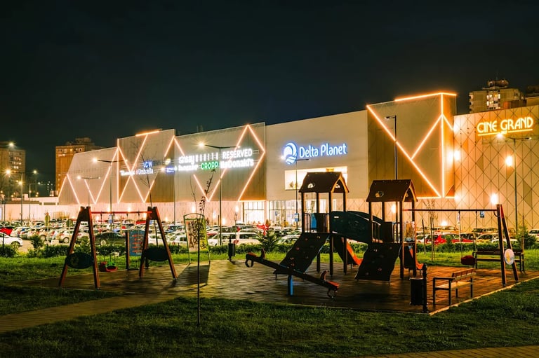 Delta Planet Mall in Nis, Serbia illuminated by neon lights at night.