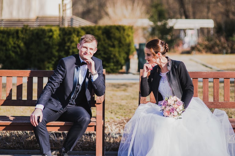 Vestuvių fotosesija Bernardinų sode - jaunieji sėdi ant suoliuko