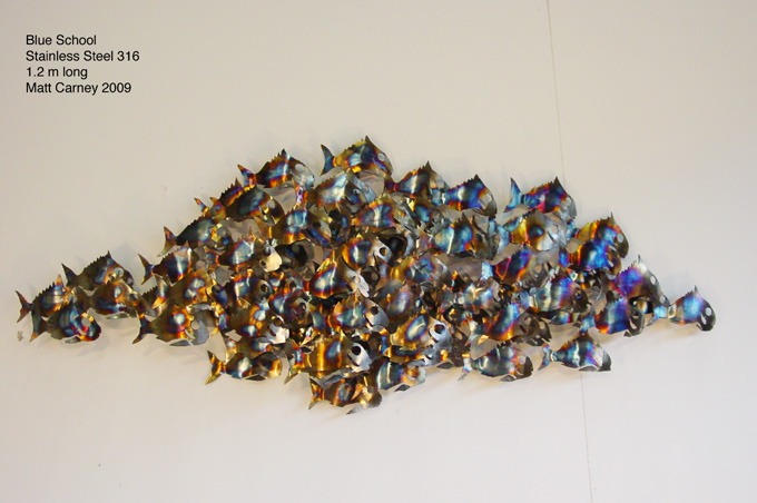 a school of fish sculpture on a wall