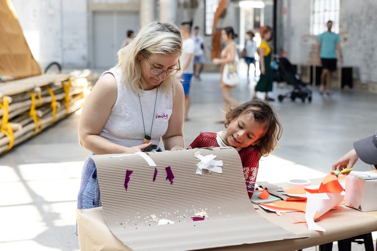 An adult and child collaborating on an artwork.