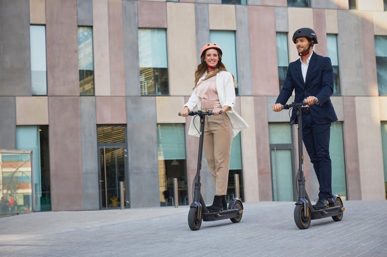 a man and woman riding scooters on a city street