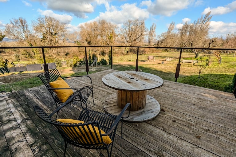 Terrasse suspendu surplombant les parcelles maraîchères et le jardin du gite des ramières à la ferme gourmande