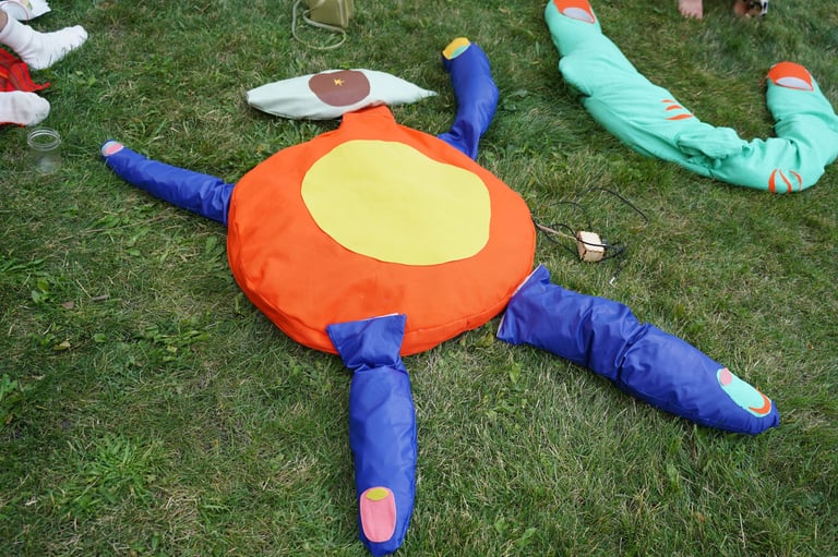 Soft sculptures of body parts arranged into a human like figure with an eye for the head.