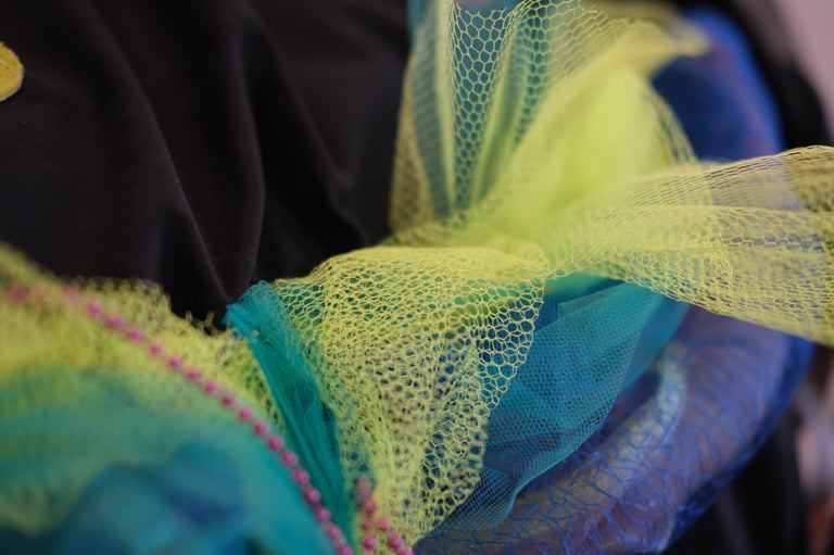 Tulle and net like fabrics twisted with pearls are sewn onto a giant velvet cushion vibrating 