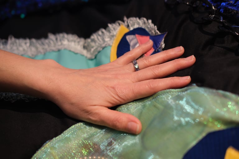 A hand touches sparkly fabrics on a velvet cushion vibrating with underwater sounds