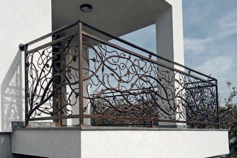 Custom decorative wrought iron balcony railing with an intricate vine and leaf design.