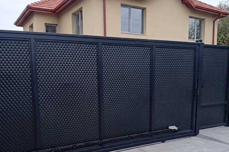 Modern black metal sliding gate with textured 3D pyramid pattern for residential home security.