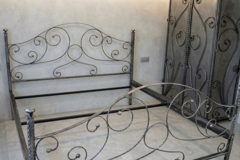 Elegant wrought iron bed frame and matching scrollwork wardrobe in a modern minimalist bedroom.