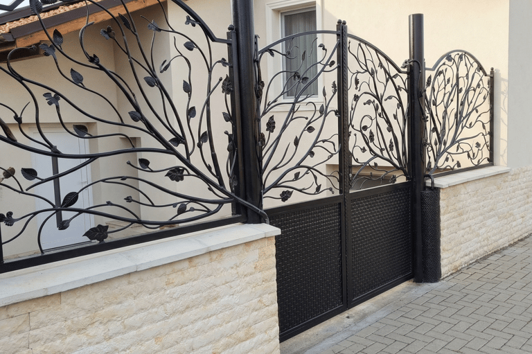 Custom decorative wrought iron gate and matching fence with a black leaf and vine design.