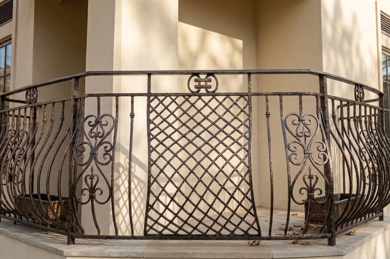 Custom decorative wrought iron balcony railing with ornate scrollwork and lattice design on a luxury home.