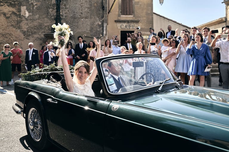 "Bride leaving the ceremony in a Provence vineyard, smiling as guests throw petals