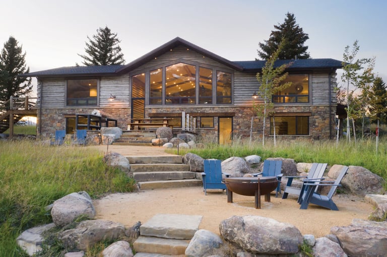 a house with a fire pit in the middle of a grassy area