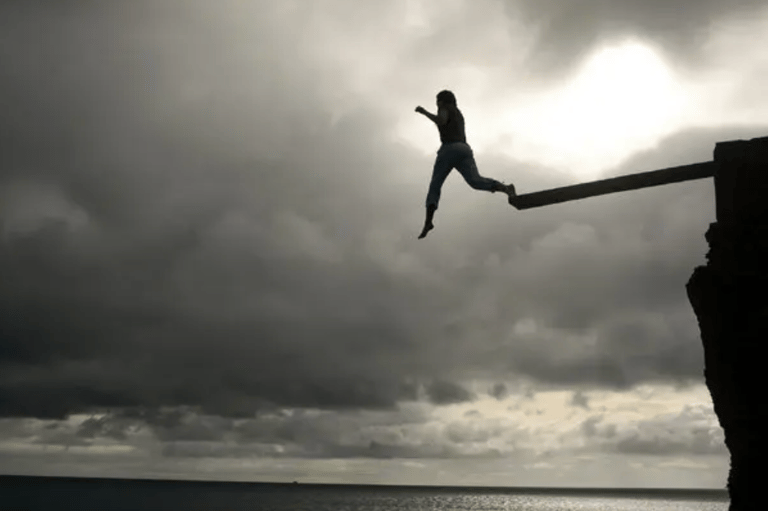 A very brave person jumping off a high diving board