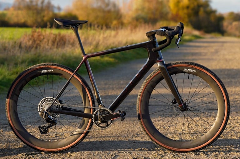 A high-performance carbon gravel bike with Zipp wheels on a sunny dirt trail.