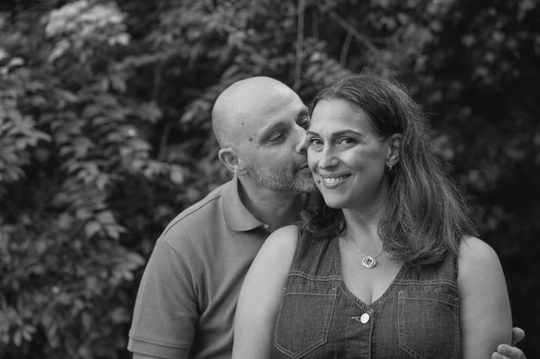 black and white image with man kissing woman on her cheek