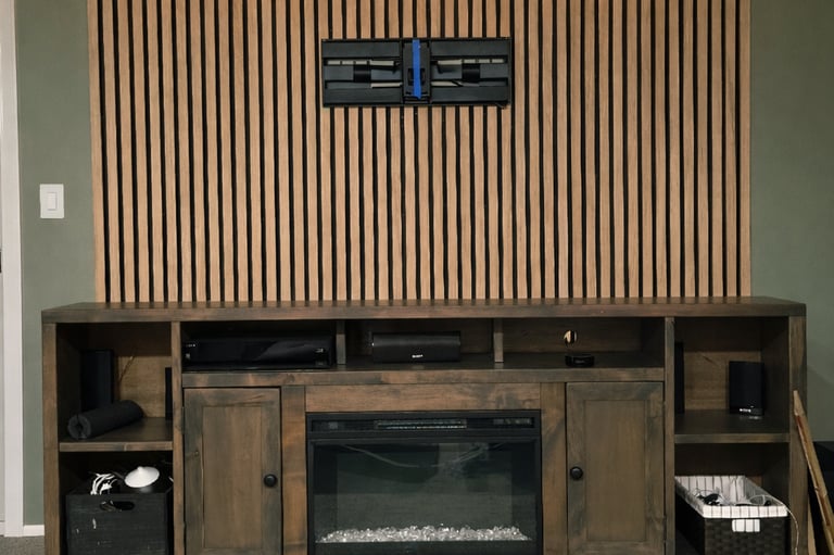 Rustic wood entertainment center with electric fireplace below a vertical slat accent wall with LED lighting.