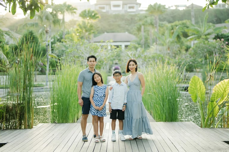 Family portrait at The Ritz-Carlton Bali surrounded by tropical gardens during a luxury family photography session.