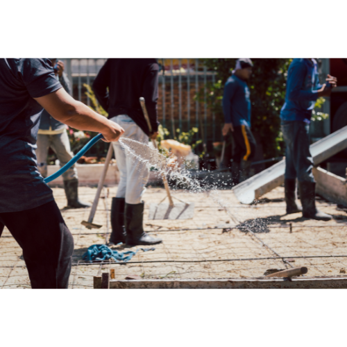 men working on a concrete foundation pouring