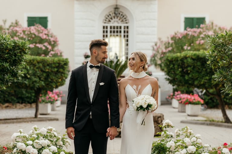 a bride and groom standing in front of a Grand Hotel Villa Parisi in Tuscany wedding