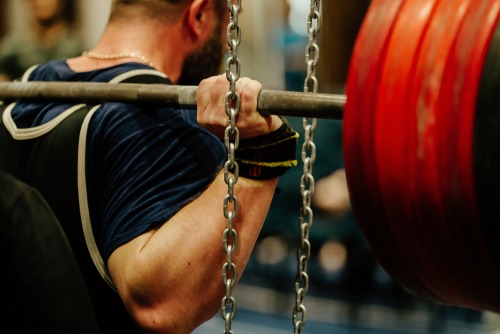 a young man squatting weights