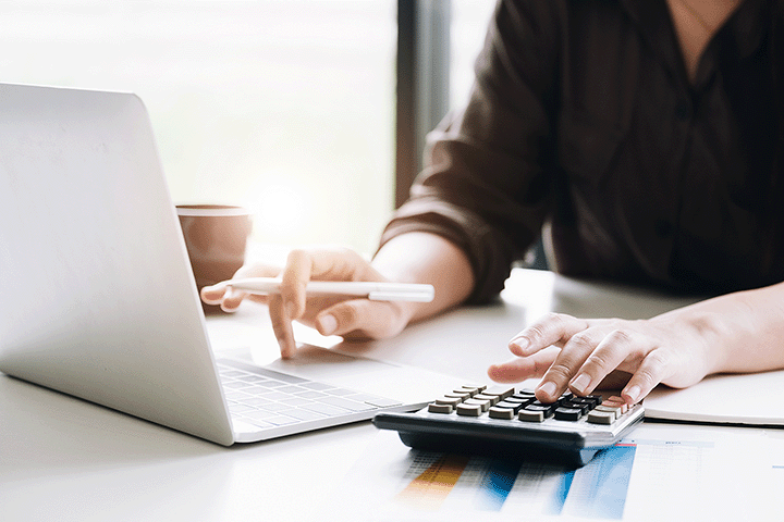 a woman sitting at a desk with a calculator