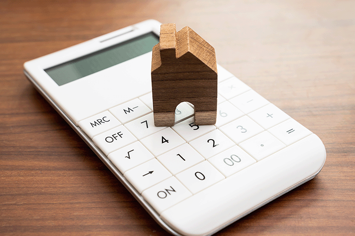 a calculator with a small wooden house on top