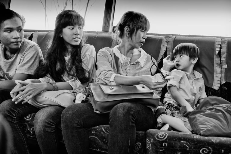 3 Indonesian women look at a young child on a Jakarta bus by photographer Peter Pickering
