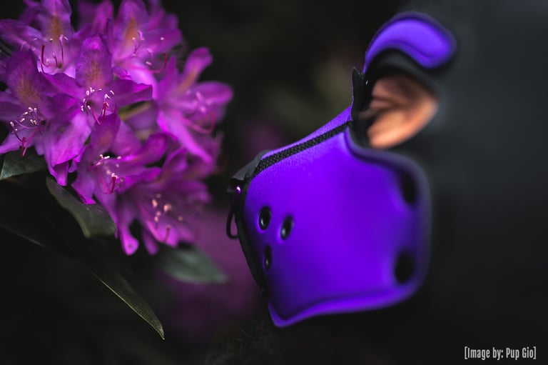 Man in pup mask sniffing flowers.