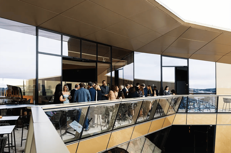 Cocktail d’entreprise en rooftop à Luxembourg pendant une soirée, avec invités en discussion.