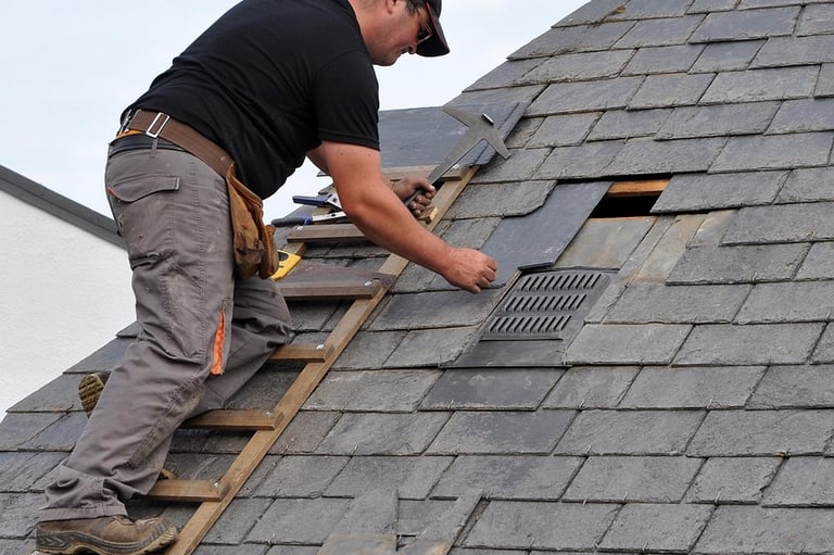 Roofing Specialists Yorkshire. Roofer repairing damaged roof tiles