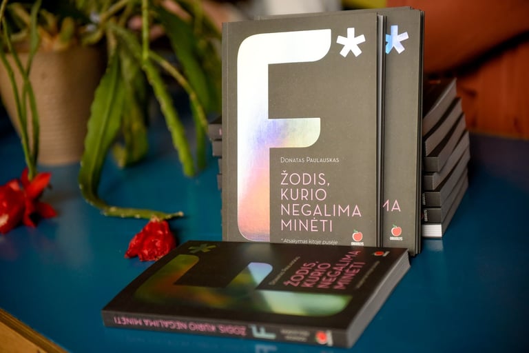 Knygos "F* - žodis, kurio negalima minėti", padėtos ant stalo.