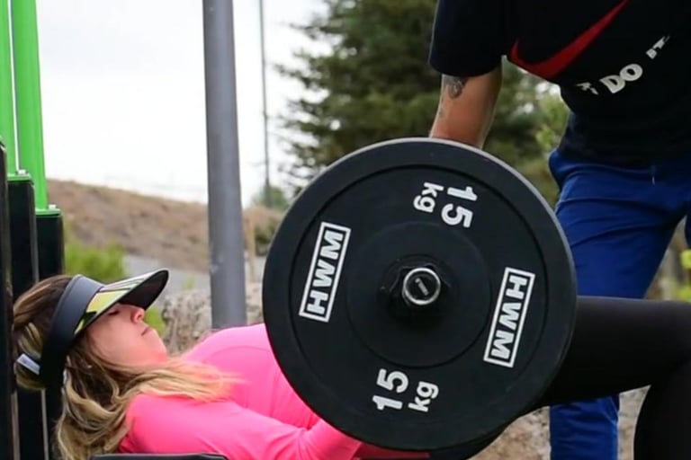 Clienta Fabi haciendo hip thrust con barra. Personal trainer a domicilio con equipo profesional