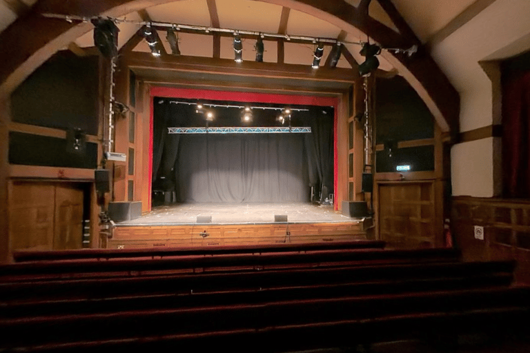 The Pleasance Theatre, a theatre with a large stage and cushioned benches.