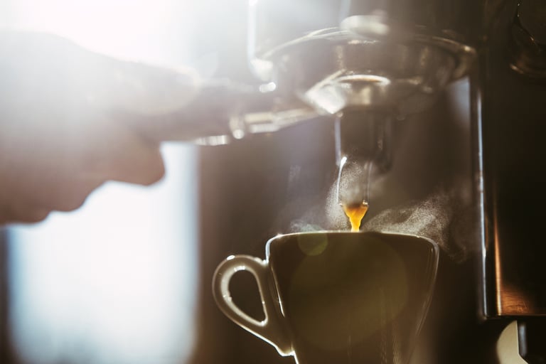 a person is pouring a cup of coffee into a cup