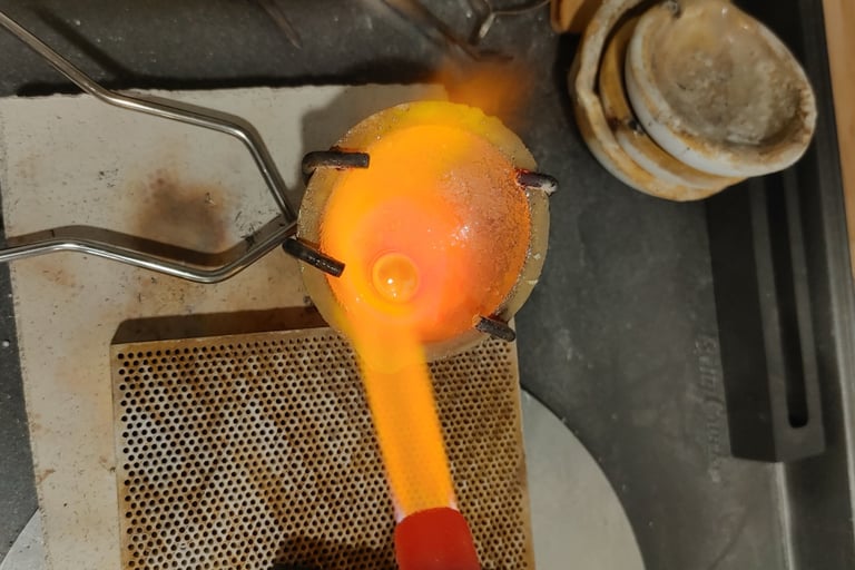 Molten sterling silver being heated and poured during the jewelry-making process.