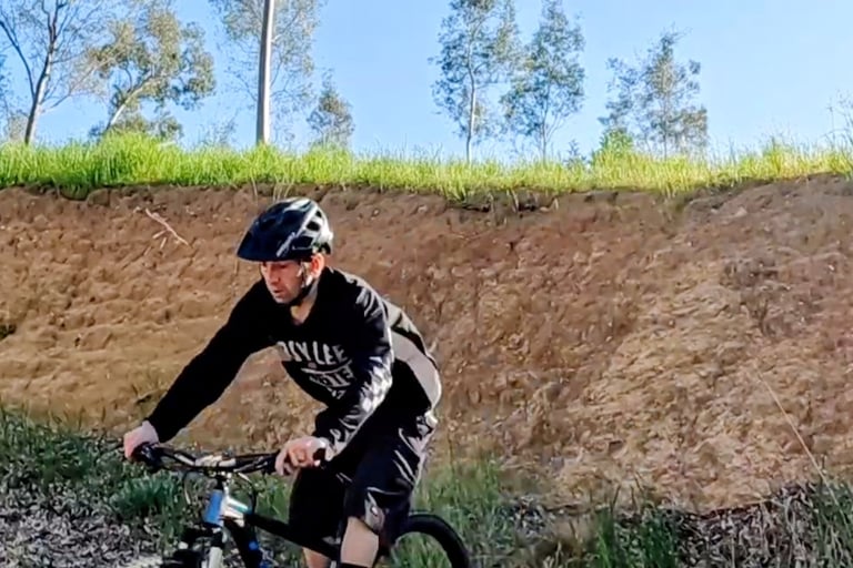 mountain biker riding out of a steep roll in