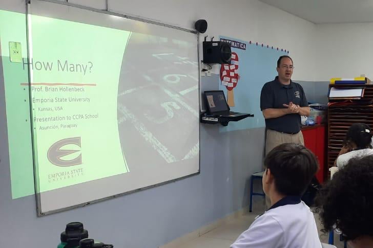 A teacher standing at the front of a classroom.