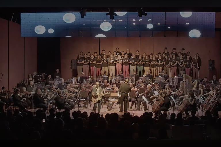 David De Mata with a conductor and orchestra in a concert hall