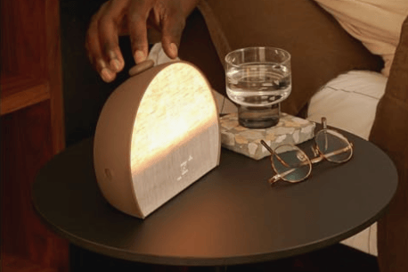 Hatch Restore 3 smart sunrise alarm clock in Putty fabric on a modern nightstand.